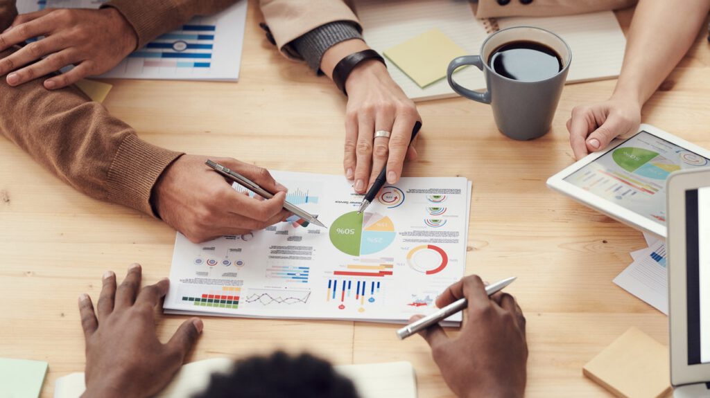 A group of three people looking at charts on a table, representing a small business start-up.