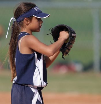 A girl playing baseball representing cash controls for non-profit kids's sports teams