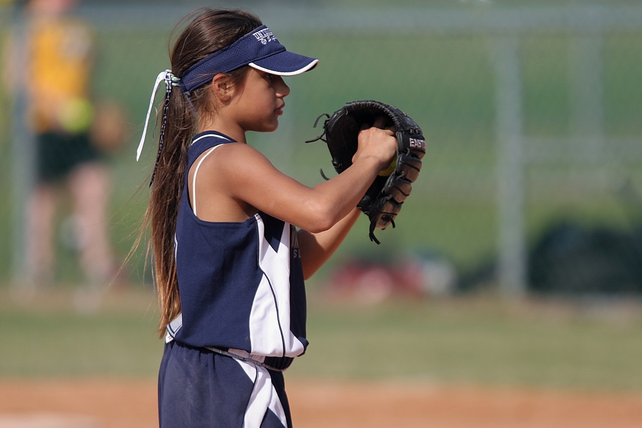 A girl playing baseball representing cash controls for non-profit kids's sports teams