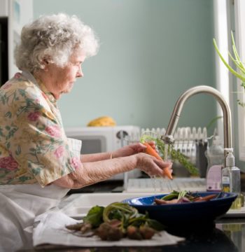 Senior woman in her new kitchen doing dishes