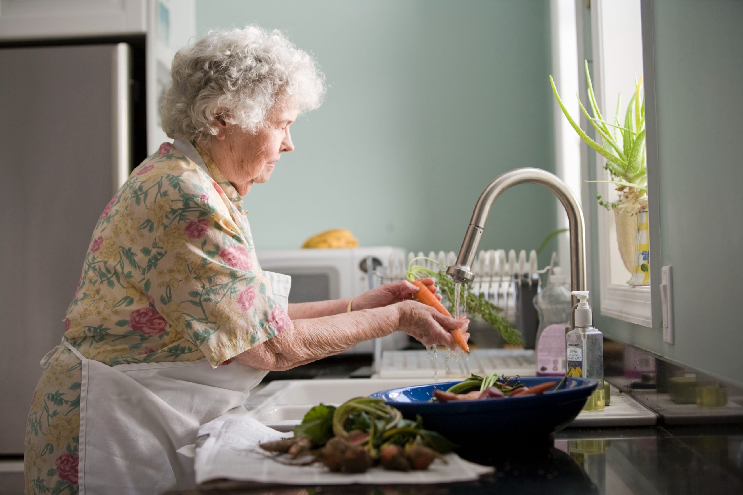 Senior woman in her new kitchen doing dishes
