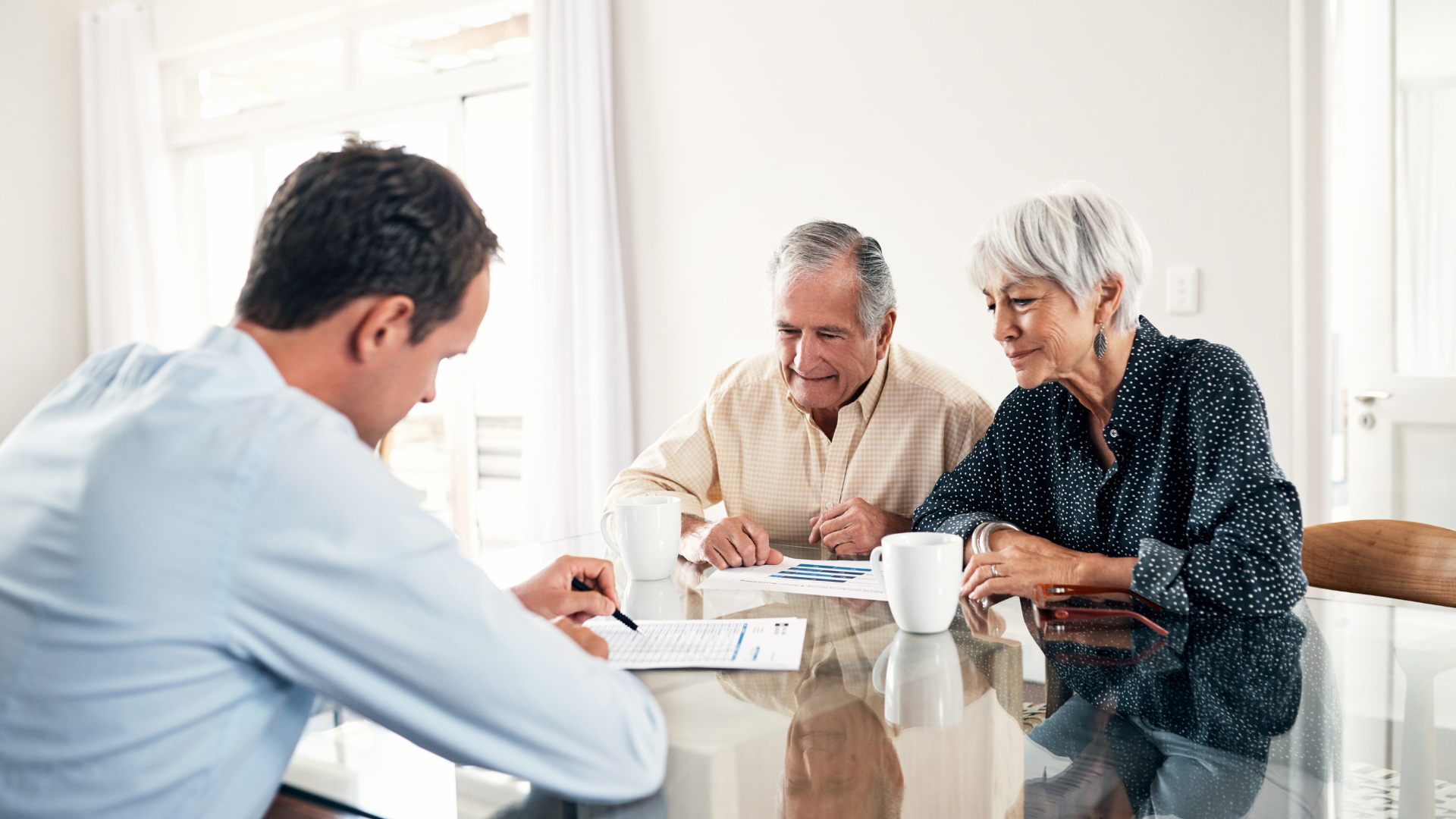 An image of two elderly business owners in Burlington speaking with their business adviser about ESOPs.