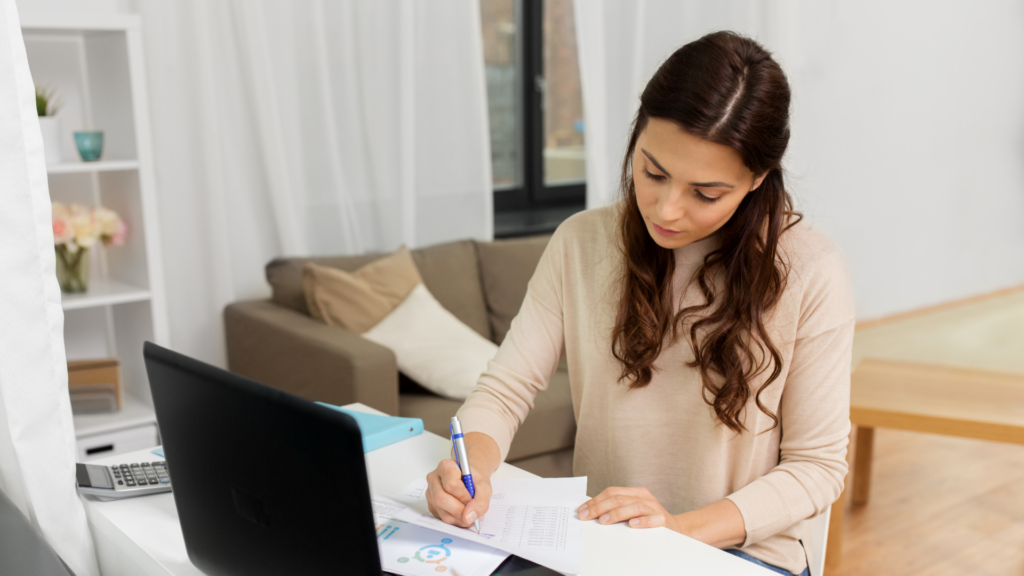 An image of a small business bookkeeper reviewing her client records.