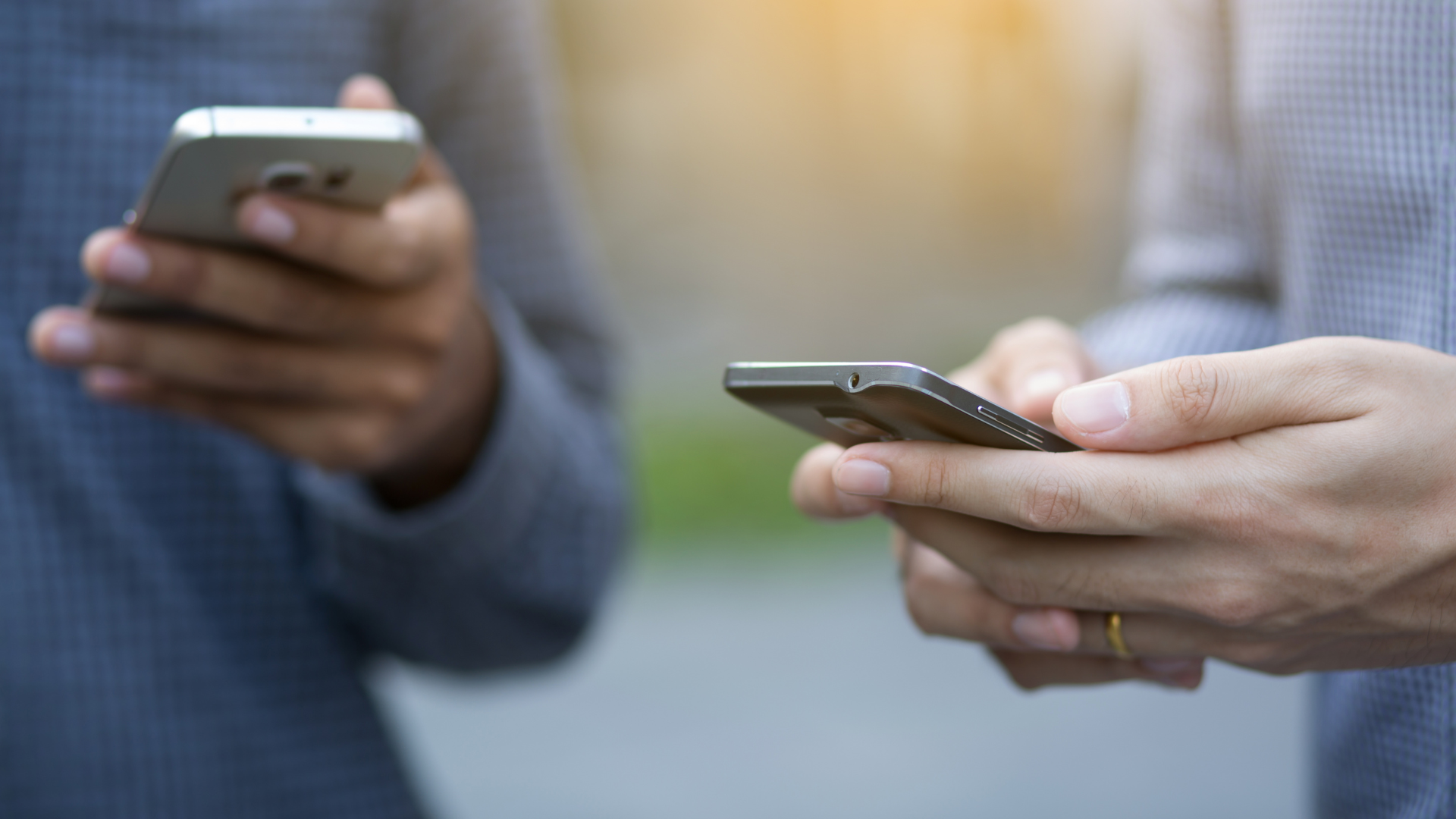An image of two business owners looking up who is the best chartered professional accounting firm in Burlington and contacting them on their phones.
